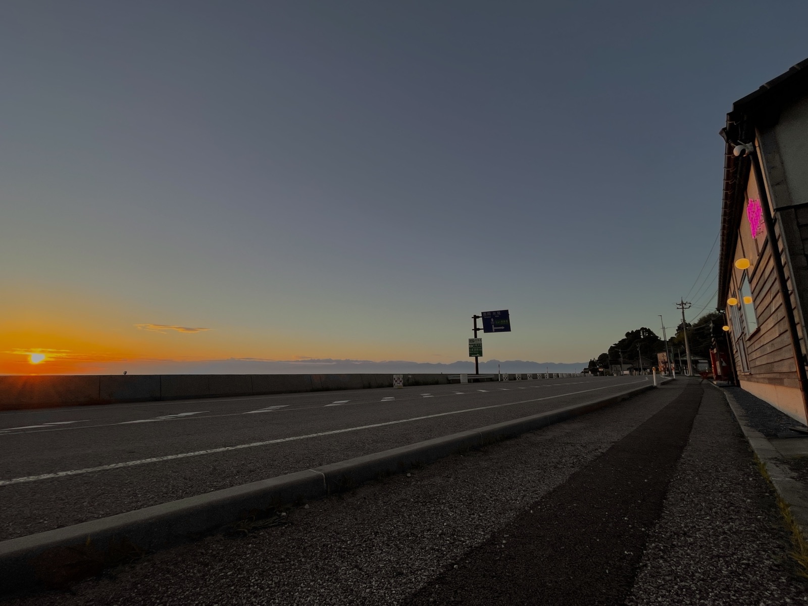 Sunrise over the water, seen from the road in front of the house